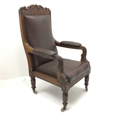  Early Victorian mahogany framed high back library armchair, scrolled foliage carved top rail, s-scroll arms carved with acanthus leaf, upholstered back seat and arms, turned supports on brass and ceramic castors, W71cm  