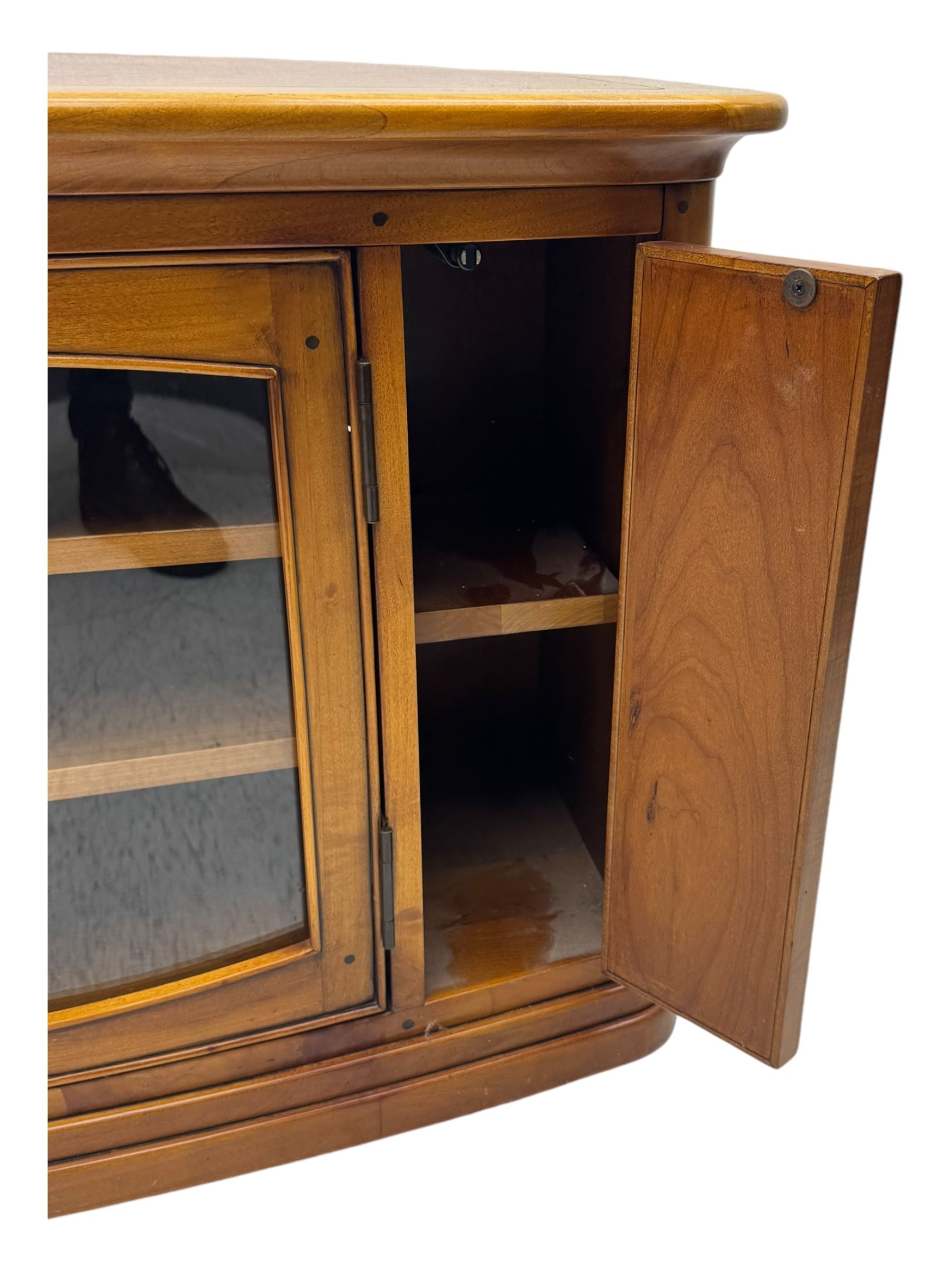 Contemporary cherry wood corner TV unit, canted top over central glazed double doors opening to shelves for media storage, flanked by side storage compartments, on a plinth base