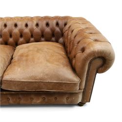 Fleming & Howland Ltd - large traditional shape four seater chesterfield club sofa, the rolled ack and arms with studwork, upholstered in buttoned tan leather with loose seat cushions, raised on large turned feet