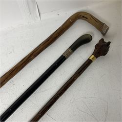 19th century painted bamboo walking cane, the handle carved as a fox with glass eyes, with gilt metal stamped LB, together with an ebonised wooden walking stick, with horn pommel and hallmarked silver collar and a curved wooden walking stick, with monogrammed white metal cap, tallest L90cm