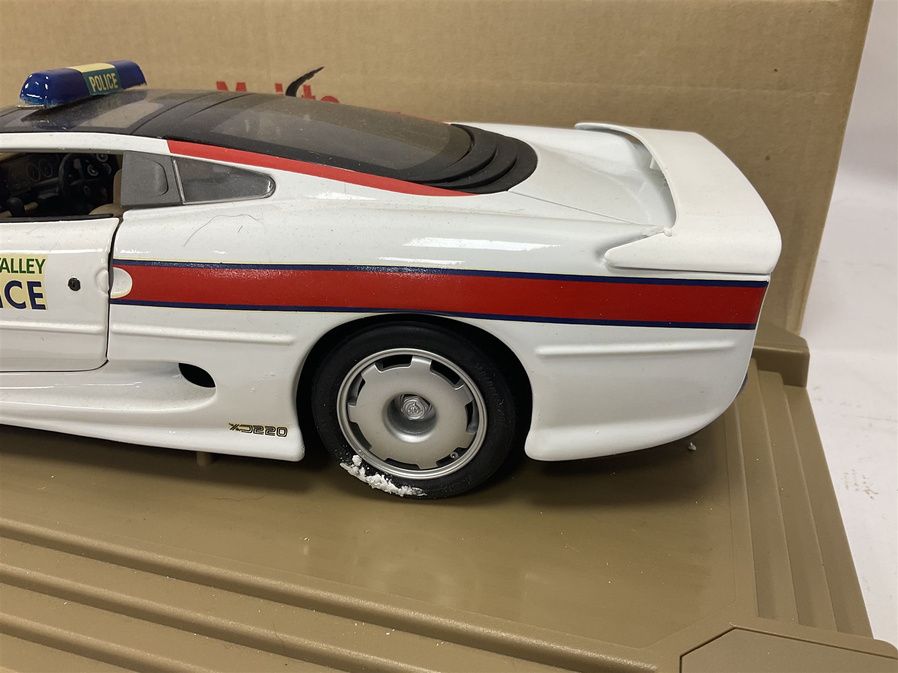 Two Maisto 1:12 scale Jaguar XJ220 scale cars comprising 1992 ‘Concept Car’ West Midlands Police car and 1994 ‘Jag 999’ Thames Valley Police Traffic Car, both on plinths with original boxes and certificates of authenticity 