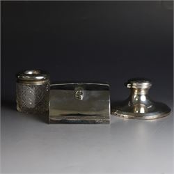 Edwardian silver fall-front ring box with loop handle, opening to reveal velvet interior with five ring spaces, hallmarked Deakin & Francis, Birmingham 1907, together with a cut glass jar with silver lid inscribed 'Hair Tidy' and a silver mounted capstan inkwell, both hallmarked 
