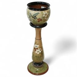 Langley Ware jardiniere and stand, decorated with birds and flowers on a light green groun...