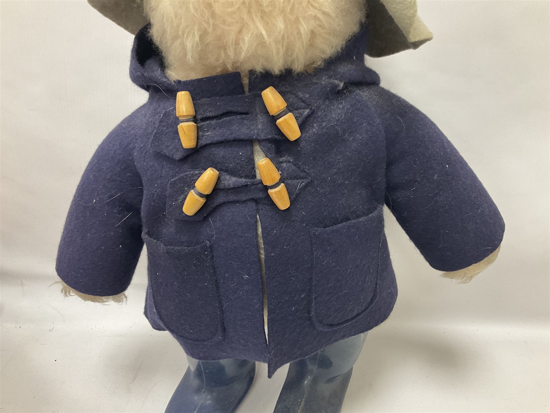 Pair of Paddington Bear teddies with amber eyes, the first example having a brown felt hat, red coat and blue PB boots with original label; the second having a grey felt hat, blue coat and blue Dunlop boots, tallest H51cm 