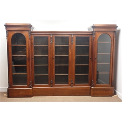  William IV rosewood breakfront bookcase, moulded cornice with scroll carved corbels above five glazed doors with adjustable shelves, on a plinth base, W285cm, H190cm, D52cm  