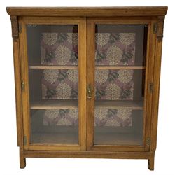 Edwardian oak and glazed bookcase, two doors enclosing two adjustable shelves flanked by uprights with applied carved foliate decoration