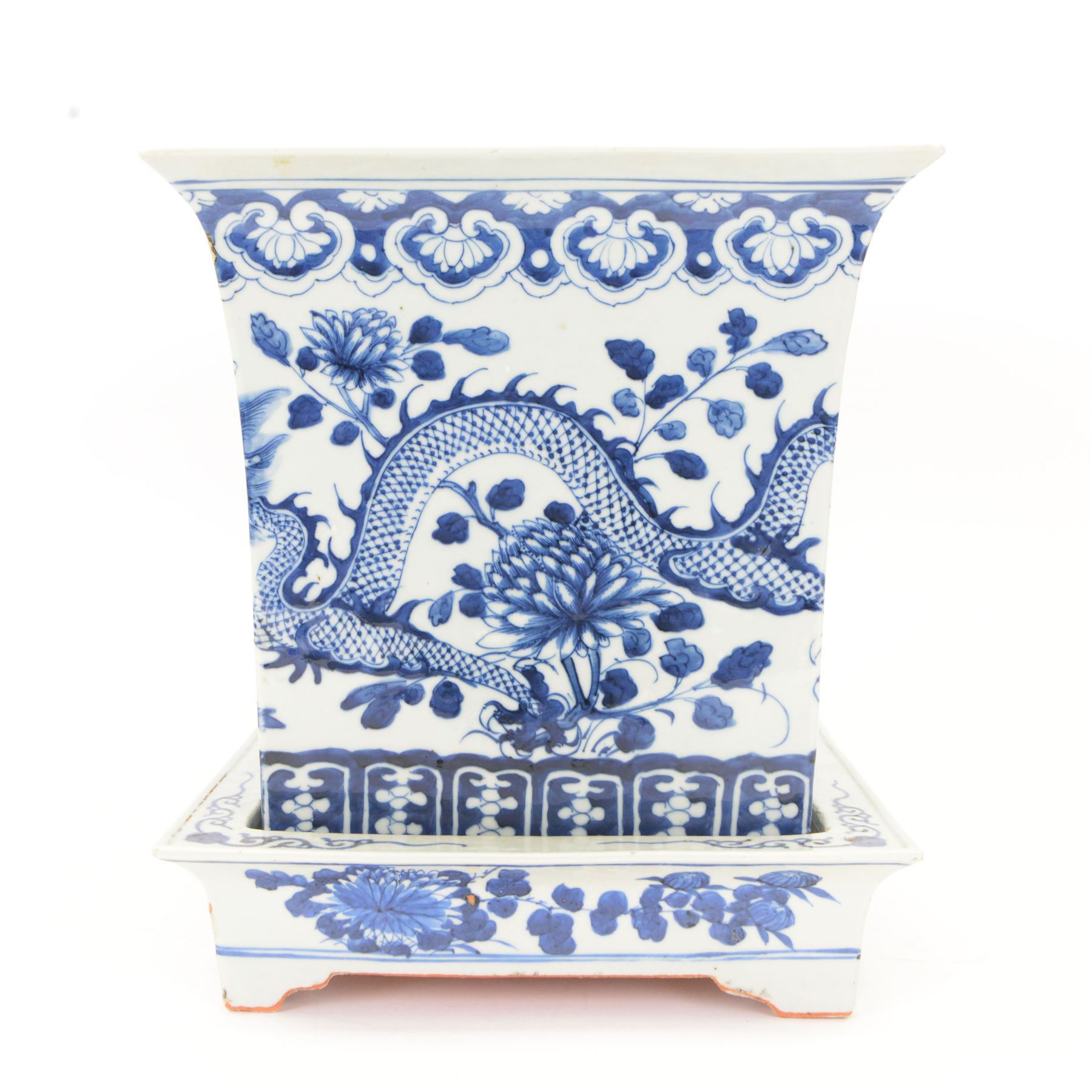 Chinese blue and white planter and stand, each of square slightly tapering and flared form, the planter decorated with two dragons and blossoming peonies, between stylised borders, the stand decorated with flower heads and vines, planter H30cm W29cm, stand H7cm D28.5cm