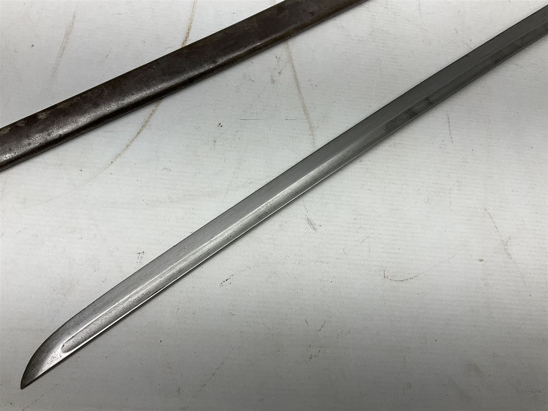 WW2 Japanese Model 1899 Type 32 'Ko' pattern cavalry sword, with 82.5cm single edged, slightly curved blade with narrow fuller, numbered 33825 to the ricasso; steel hilt with chequered backstrap and grip ears with wooden chequered grip and leather finger loop; locking action; in steel scabbard with single hanging ring L99.5cm overall