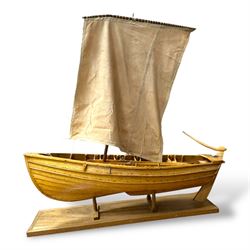 Wooden model of a fishing coble, with single canvas sail, upon a rectangular wooden plinth, total H74cm