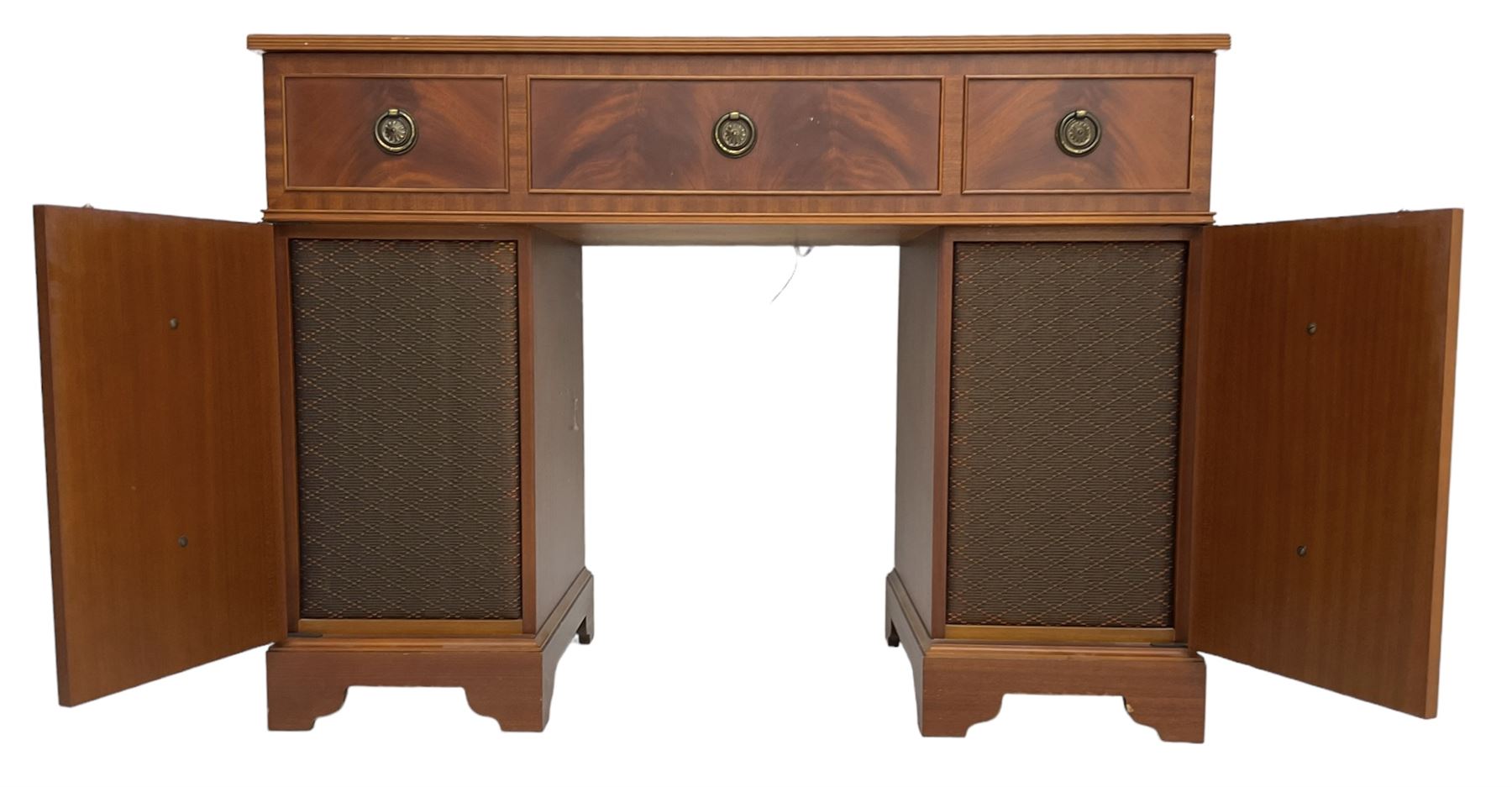 Music system in the form of a Georgian design twin pedestal desk, the reed moulded rectangular top hinges to reveal Garrard turntable with Dynatron Amplifier, fitted with speakers enclosed by two doors disguised as drawers, on bracket feet