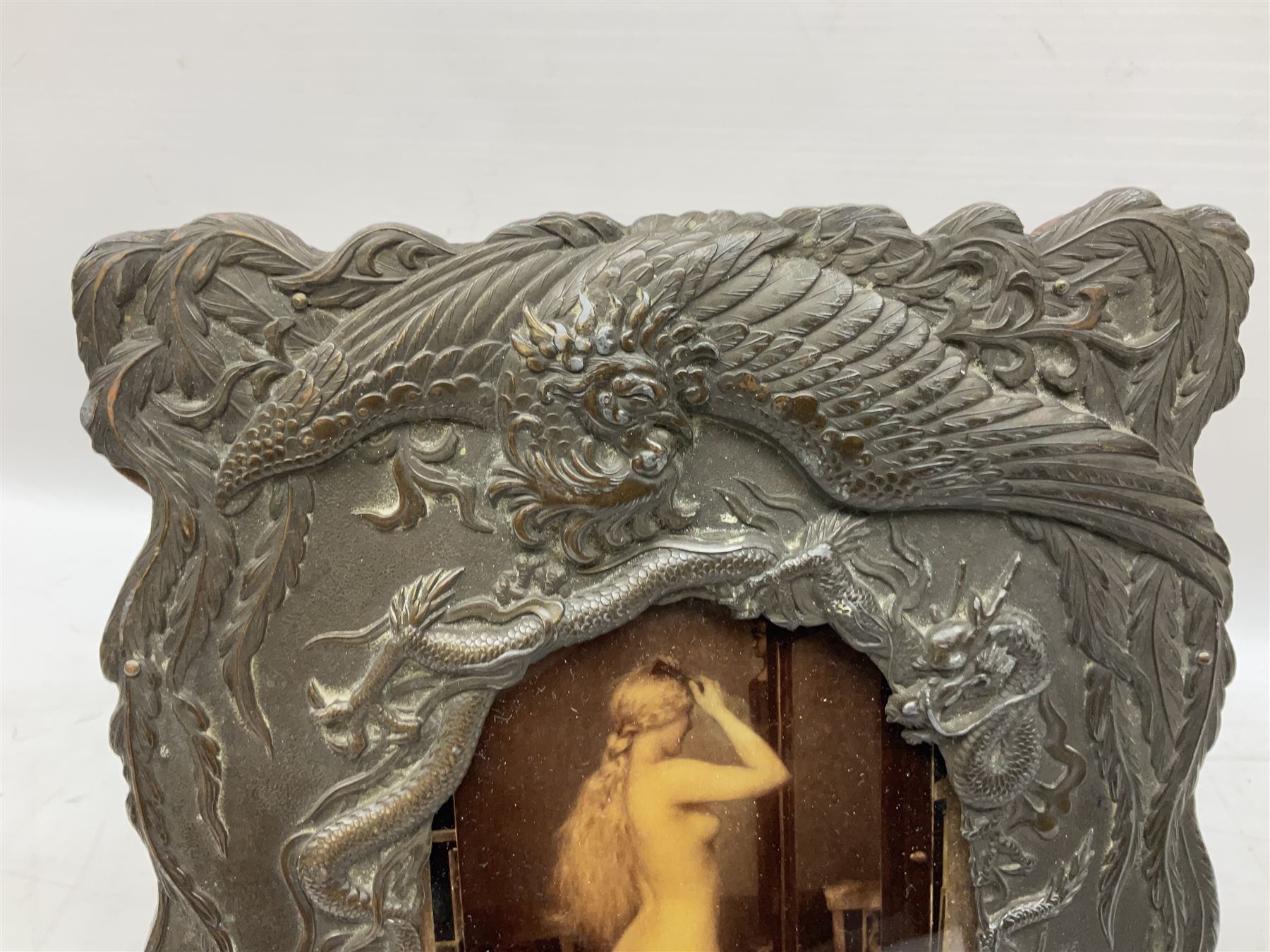 Japanese bronzed antimony frame, decorated with dragons and ho ho birds, easel stand to reverse, containing Continental crystoleum of female nude, H24cm