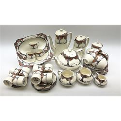 Crown Ducal tea and coffee wares decorated in the Orange Blossom pattern with fruiting trees upon a white glazed ground, comprising tea pot, coffee pot, hot water pot, two milk jugs, cream jug, preserve pot and cover, footed dish, small serving plate, four side plates, five smaller octagonal examples, four teacups and four saucers, eleven coffee cans and eight saucers. 
