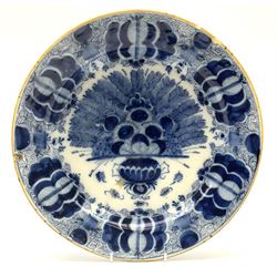 18th century Delft blue and white peacock pattern dish, painted with a fan of peacock feathers behind an urn of fruit and flowers, D34.5cm. 