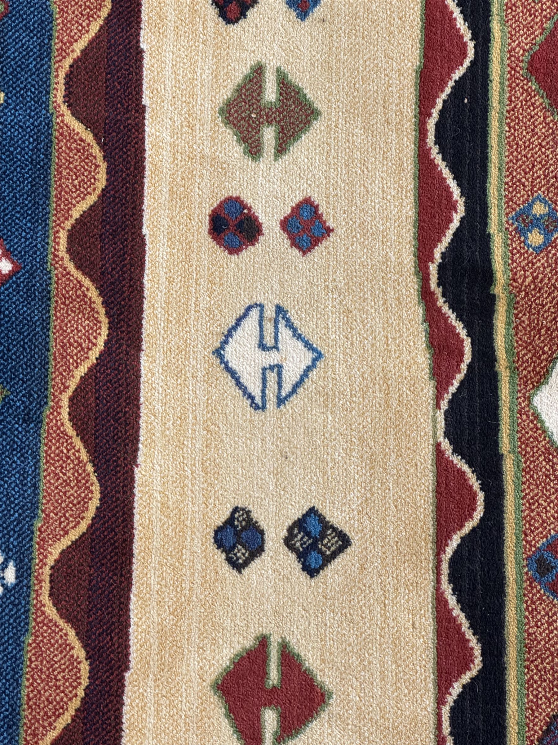 Late 20th century Louis De Poortere Belgian Shalamar wool ground rug, featuring a vibrant multi-coloured geometric design with stacked rectangular borders surrounding two central medallions, finished with fringed ends