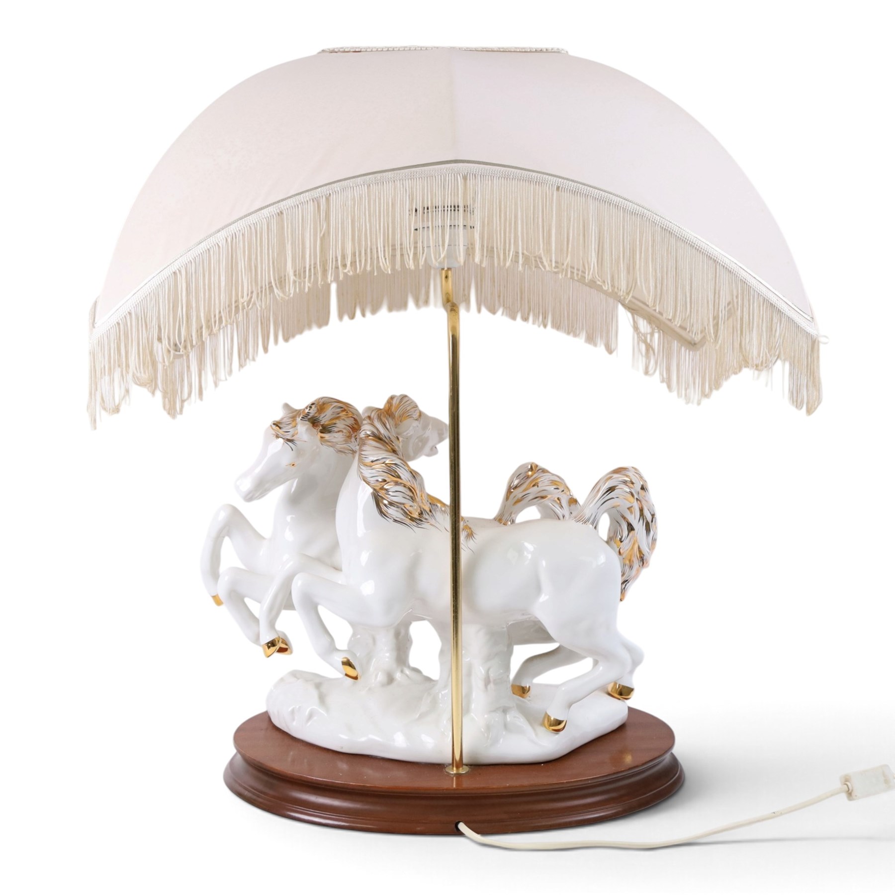 Italian-style ceramic table-lamp featuring two white running horses with gold accents, with cream tasselled lampshade, upon a wooden base, approx. H60cm W40cm