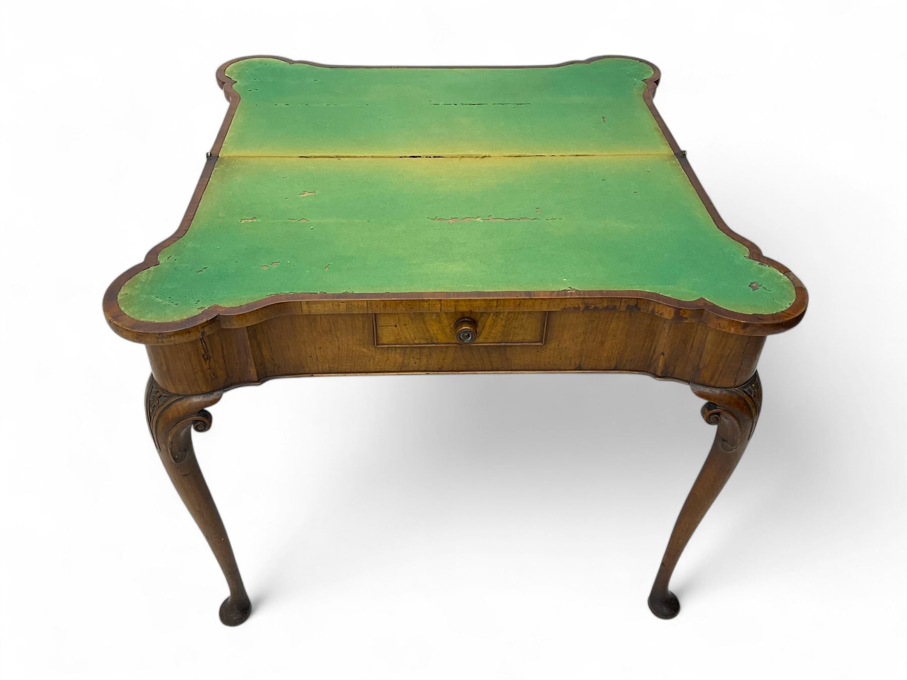 Georgian walnut fold-over card table, shaped rectangular top opening to reveal a baize-lined surface, supported by a concertina pull-out rear mechanism, frieze fitted with single drawer, raised on cabriole supports with foliate carvings terminating in pad feet