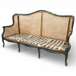 Early 20th century French bergère settee, the shaped caned back flanked by caned sides and scrolling arms, moulded beech frame with dark painted finish, serpentine seat rail with webbing, on cabriole legs with pad feet