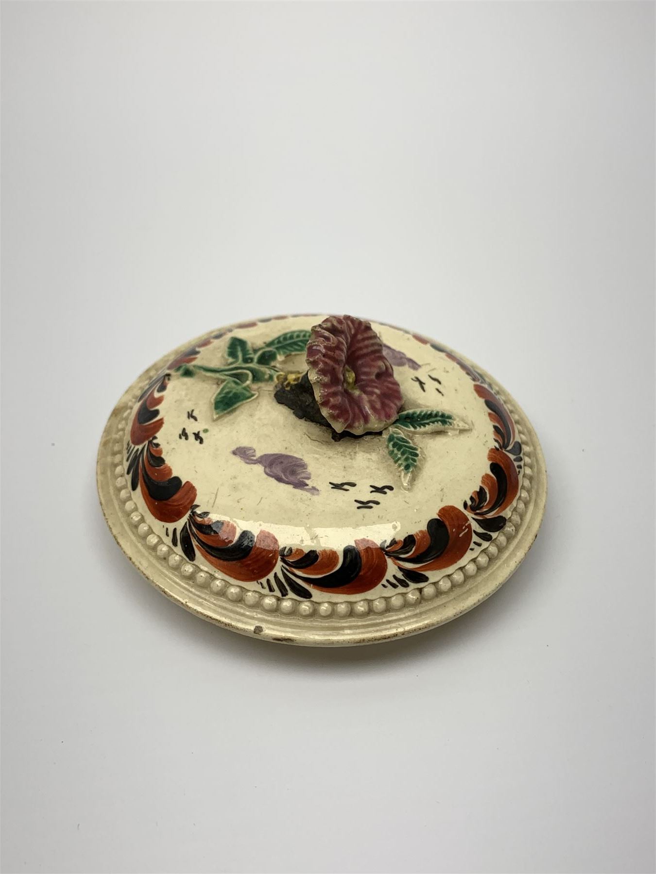 18th century creamware teapot, probably Leeds, with reeded entwined handle and floral finial to the cover, the body with hand painted polychrome decoration of figure to one side, and floral spray to the other, collectors paper label beneath inscribed Leeds Pottery, H11.5cm