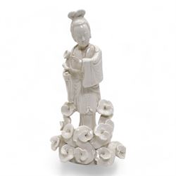 Chinese blanc de Chine figure of Guanyin, wearing robes and standing upon a lotus base, H25.5cm, a jichimu carved wooden stand, and carved greenstone figure of an immortal (3)