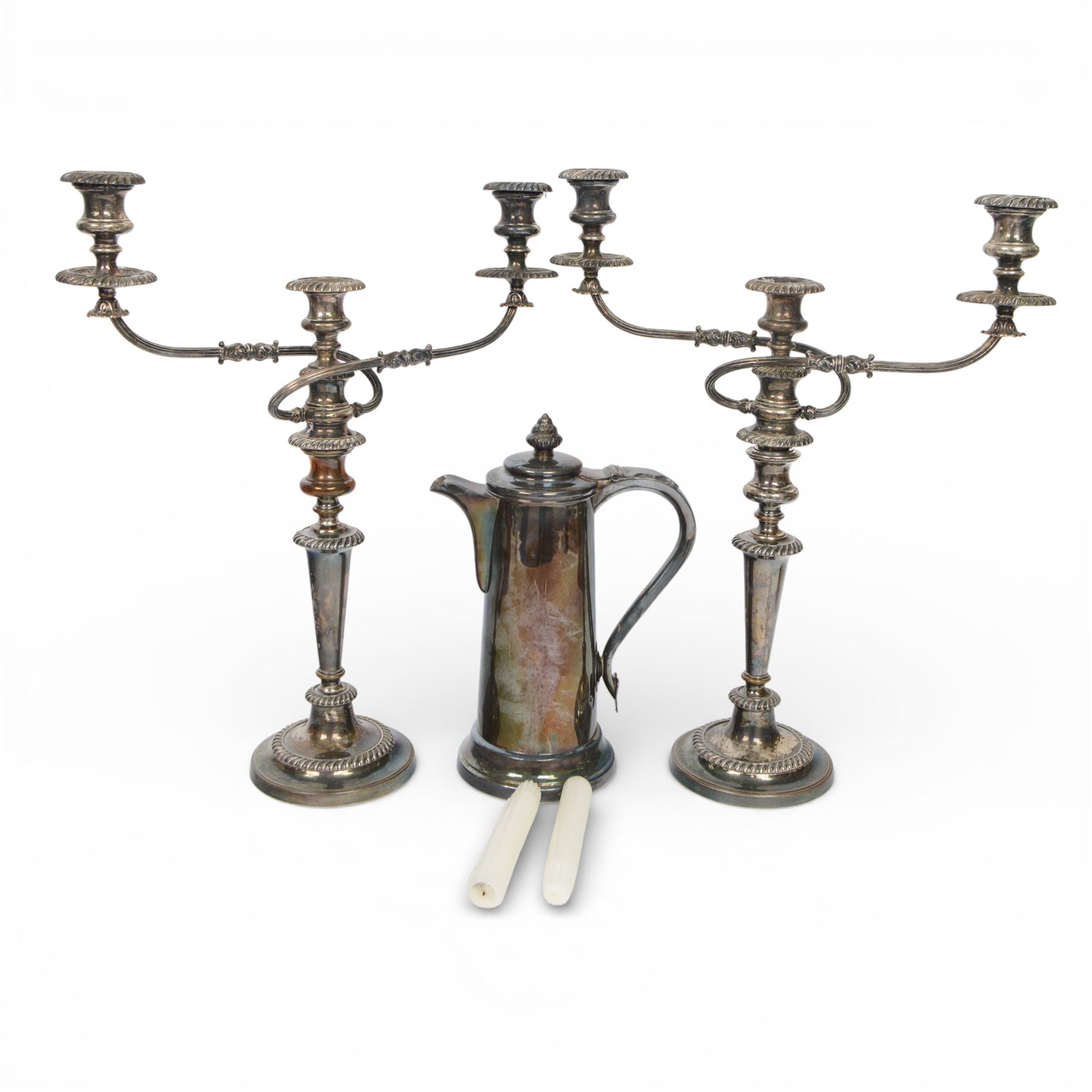 Pair of silver plated three branch candelabra, each with three urn-shaped sconces, with scroll arms, tapering stem upon a circular base, together with silver plated wine flagon