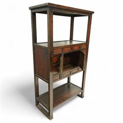 20th century Korean stained pine and elm cabinet, rectangular top over central panelled cupboard doors with metal ring handles, framed by geometric mouldings, open shelf above and below