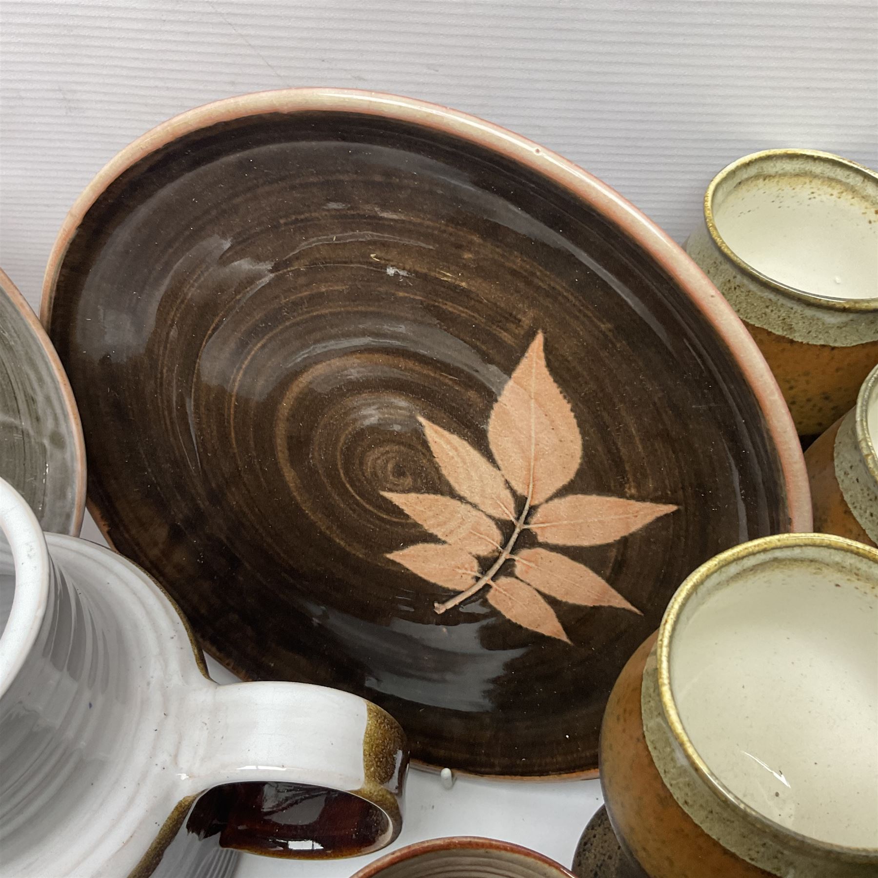 Wold studio pottery tankards, in various colours and relief decoration together with other studio items including vases, jugs and pots 