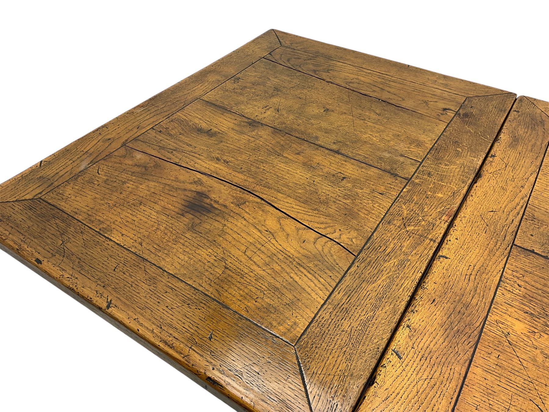 Early 20th century Jacobean design draw-leaf oak dining table, rectangular top with carved frieze depicting scrolling foliage and grape clusters, sliding extending leaves, raised on robust turned supports united by H-stretcher  