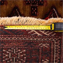 North East Persian Turkoman hand-knotted rug, camel brown field decorated with repeating rows of octagonal guls, interspersed with small geometric motifs enclosed within narrow guard borders in a palette of madder red, brown, and ivory, with cotton fringe ends  