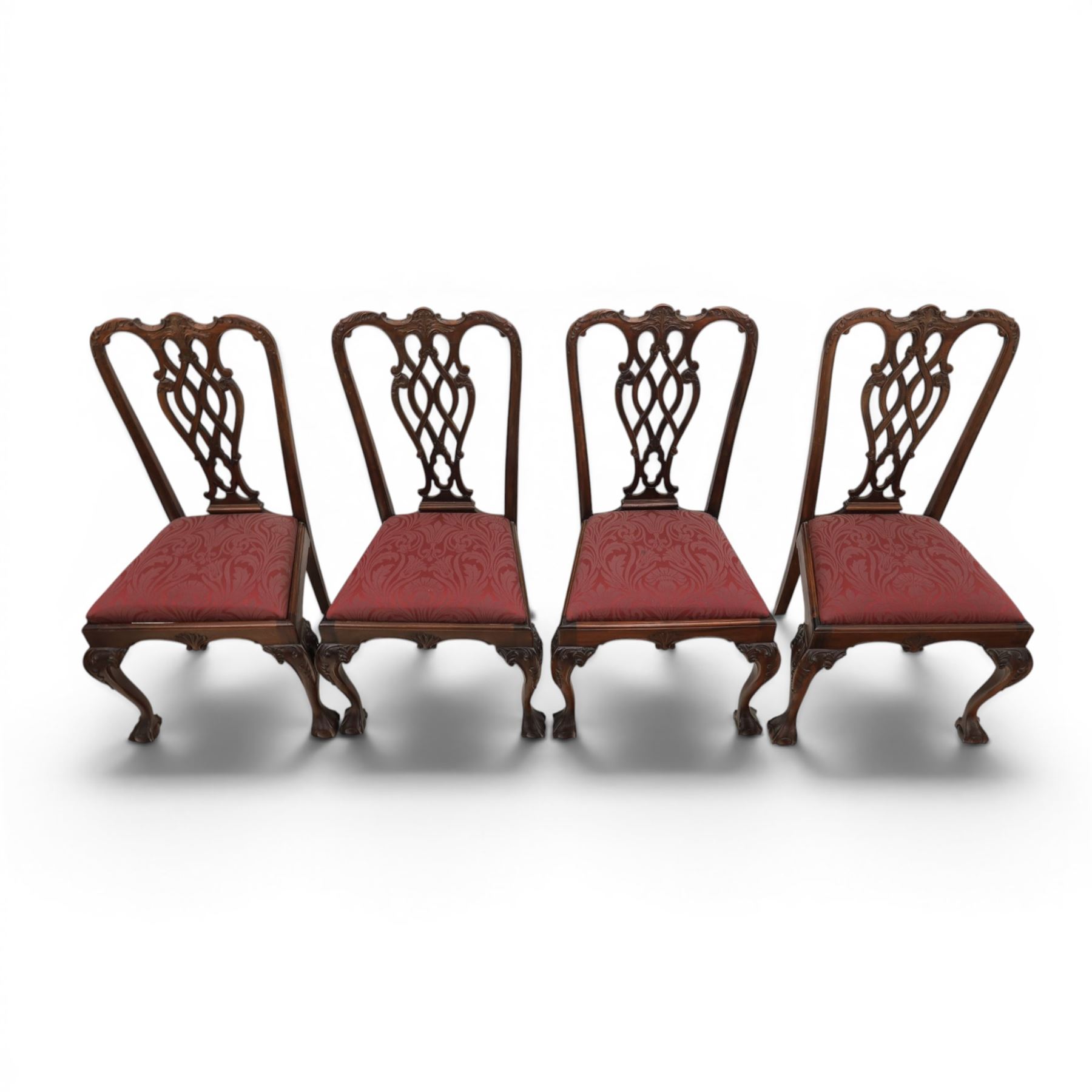Chippendale design set of ten (8+2) mahogany dining chairs, serpentine cresting rails with carved detail over pierced ribbon-tied splats, red damask upholstered drop-in seats, on cabriole supports with acanthus carved knees and claw and ball feet