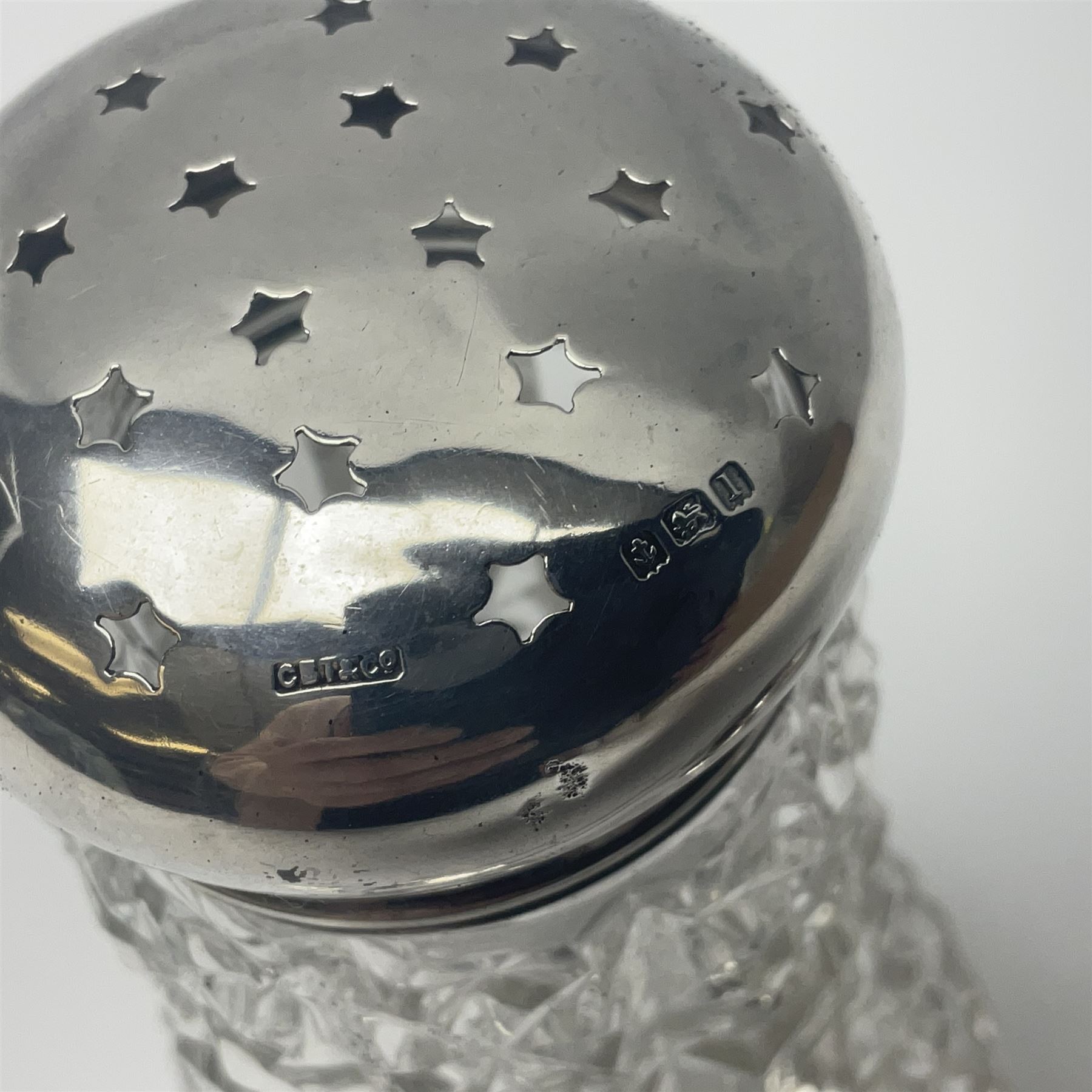 Early 20th century cut glass silver sugar caster, hallmarked C B Thomas & Co, Birmingham 1910, together with silver pepper, hallmarked, a continental silver pickle fork, stamped 800 and a plated cake fork