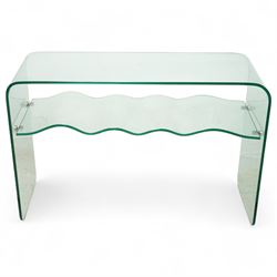 Contemporary glass two-tier console table of minimalist design, rectangular top with a single sheet of curved glass with a waved under tier supported with metal fittings 