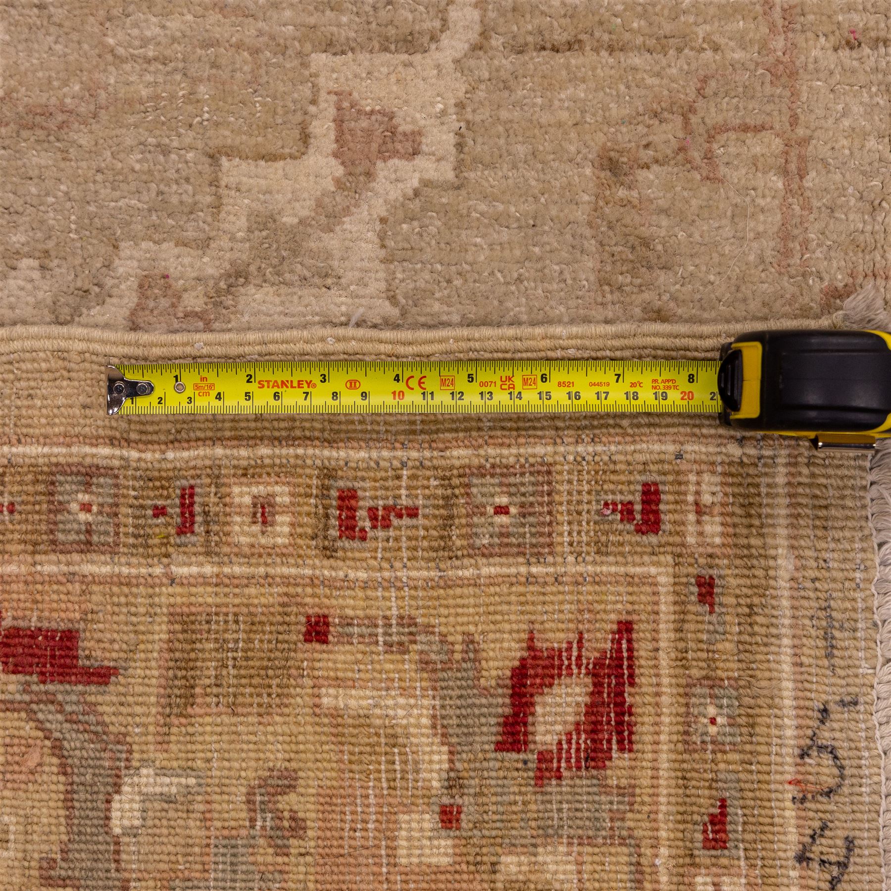 Afghan Ziegler hand-knotted carpet, soft ivory field woven with an elegant arrangement of scrolling vines and stylized palmettes with a central medallion, palette in muted tones of beige, terracotta, and blush pink, within a broad complementary border of angular floral devices and reciprocal guard stripes, fringe ends