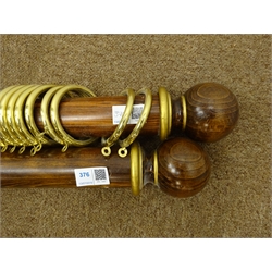  Two medium wood and gilt circular curtain poles with round finials,each with brass fittings and fourteen rings, L180cm  
