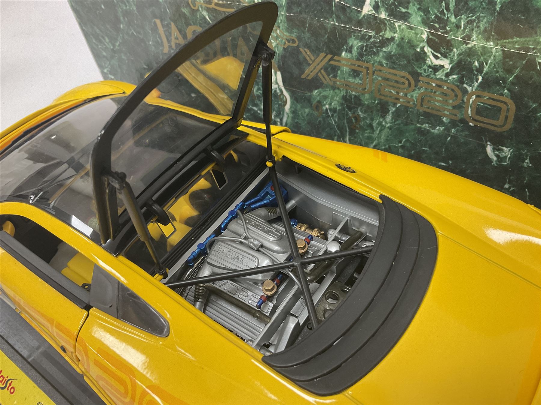 Two Maisto 1:12 scale Jaguar XJ220 ‘Racing’ cars in yellow, both on plinths in original boxes 