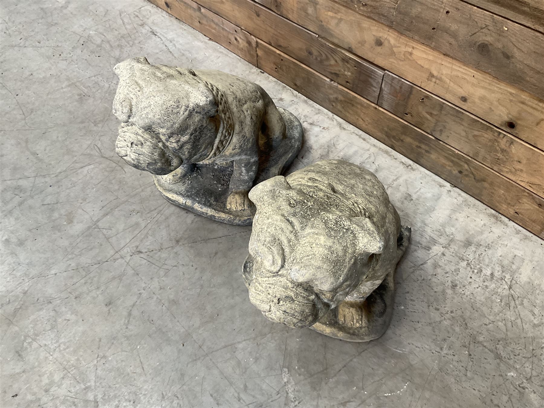 Pair of cast stone garden British bulldogs, on shaped plinths