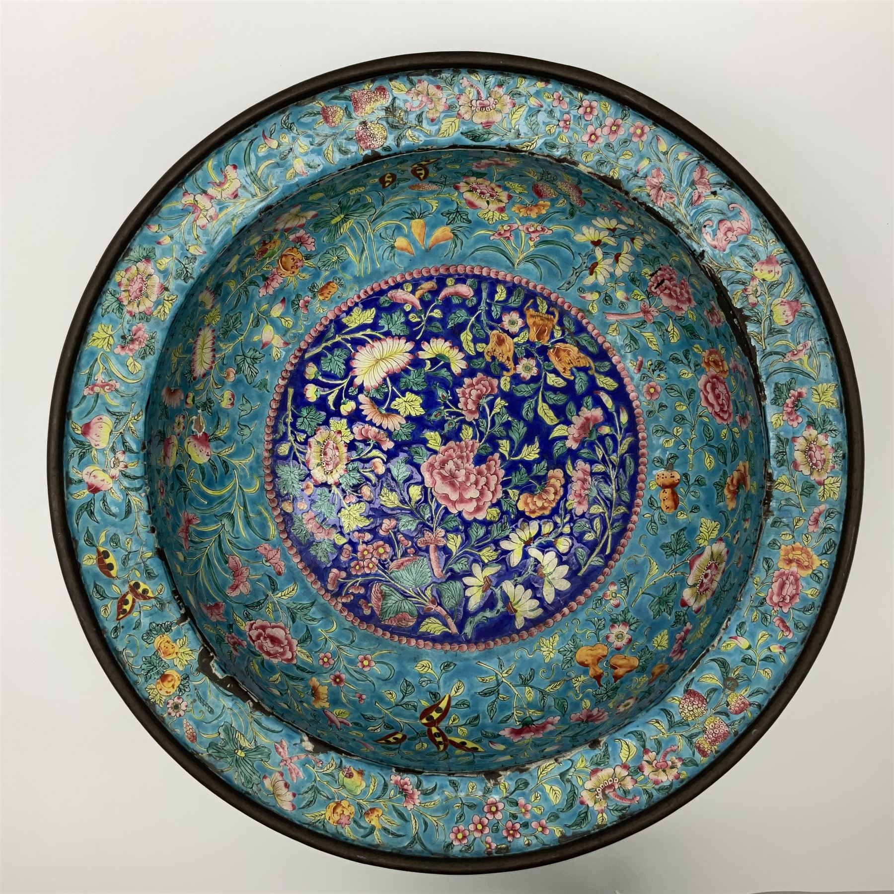 18th/19th century Chinese Canton enamel basin, the circular basin with flat everted rim, decorated with scrolling foliate and fruit decoration on a blue ground, D43cm
