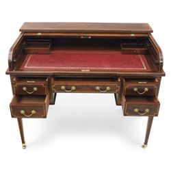 George III style inlaid mahogany tambour desk, the roll top enclosing fitted interior with small drawers and compartments above inset leather writing surface, over three frieze drawers, raised on square tapering supports with brass caps and castors