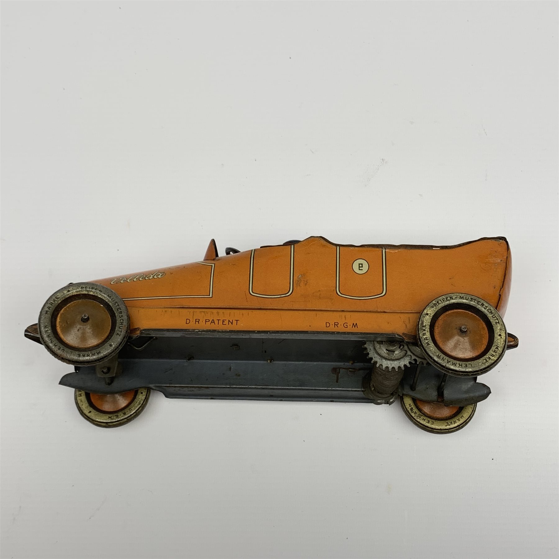 Early 20th century Lehmann clockwork tin-plate open top car with chauffeur, the bonnet inscribed 'Velleda', folding seats and bench seat to the back and integral key, various patent dates up to 1913, L25cm
