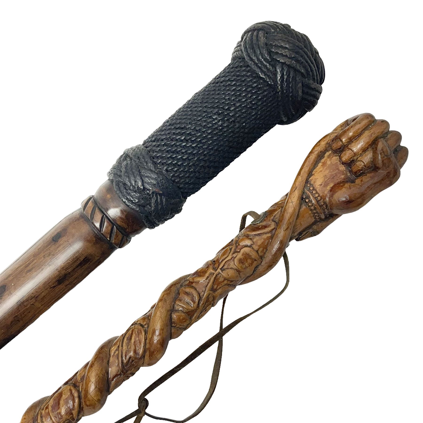 19th century wooden walking stick, the handle carved as a snake within a clenched fist, the cane carved with foliate and cross hatched decoration, with a metal spike to base, together with a turned wooden walking stick, with lacquered rope nautical knot handle, tallest L96.5cm