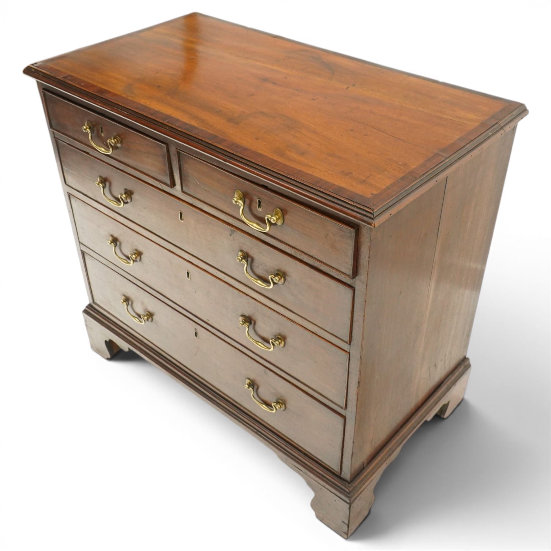 Late 18th century mahogany chest of drawers, rectangular top with moulded edge above two short and three long graduated drawers, with brass swan neck handles, shaped apron and bracket feet
