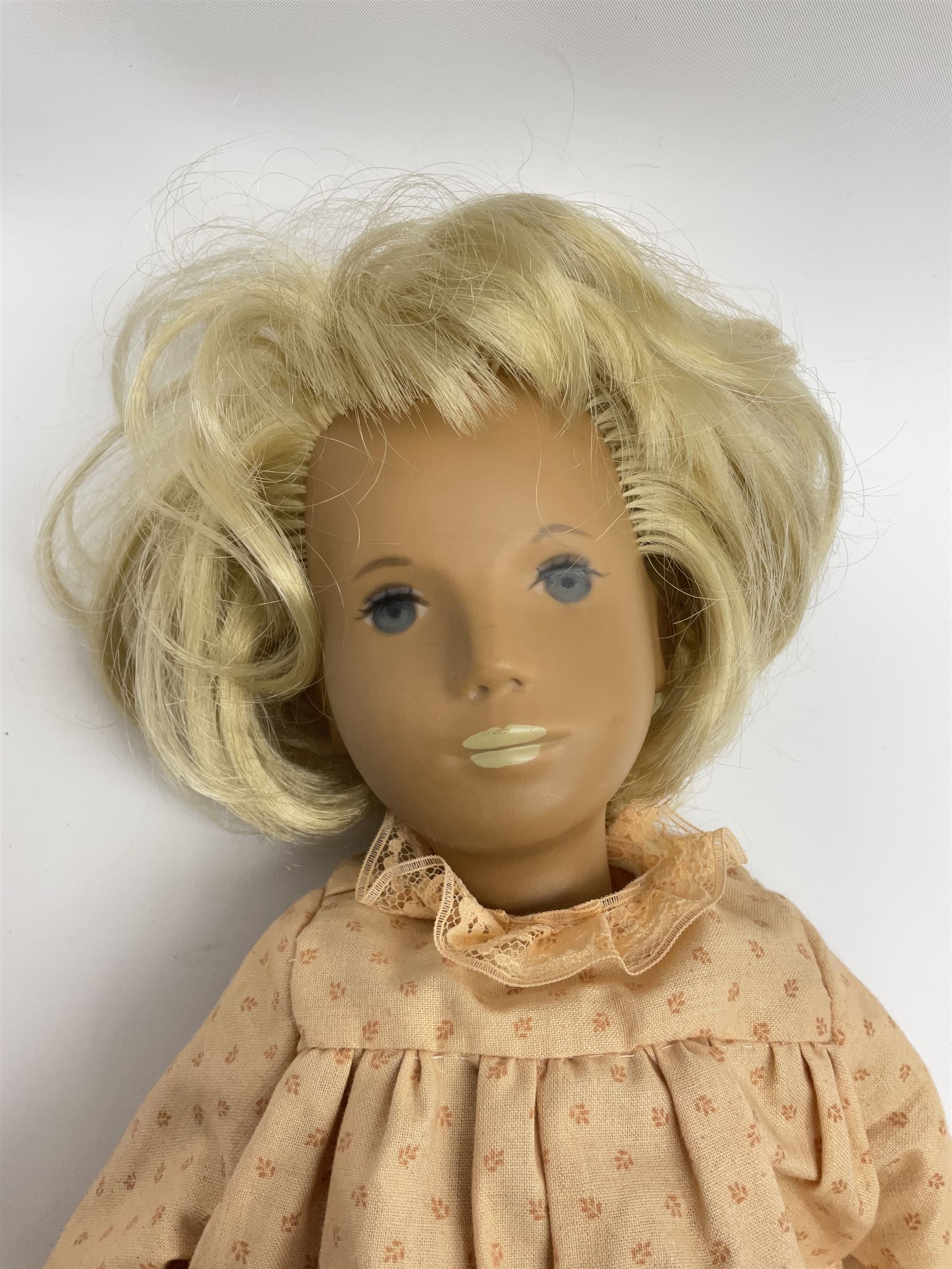 Sasha Morgenthaler vinyl doll, the girl's head with painted blue eyes and lips and short blonde hair, the jointed body donning a peach floral dress with matching underclothes, unmarked, H41cm