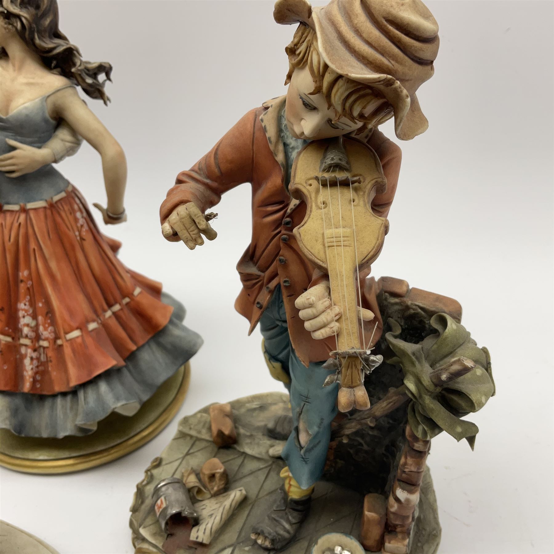 Four Capodimonte figures, comprising Shoemaker by T Galli, Tramp on Bench by Roby B, The Fiddler by Maria Angela, and Gypsy Dancers by Sandro, each with accompanying certificate, plus a Beswick matt glazed horse, and small Beswick pheasant. 