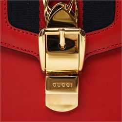Gucci - ‘Sylvie’ Small Shoulder Bag, introduced circa 2016 under Alessandro Michele, in red calfskin leather with signature web stripe, gold-tone chain and buckle fastening and hardware, flat leather shoulder strap with alternative web-stripe grosgrain strap, unused with original dust bag