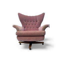 Paul Conti for G-Plan - 'Blofeld' Model 6250 swivel wingback armchair, upholstered in pink velour button back fabric, on teak base with castors