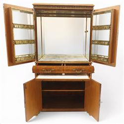 Early 20th century Art Deco burr maple mirrored drinks cabinet, rectangular top with gilted cornice, twin cabinet doors with gilt escutcheons, enclosing a mirrored interior with shelves behind the doors, marble base to the top section above two short drawers over a marble inset slide, the lower cabinet with cabinet doors flanked by pilasters, raised on gilted bracket feet 