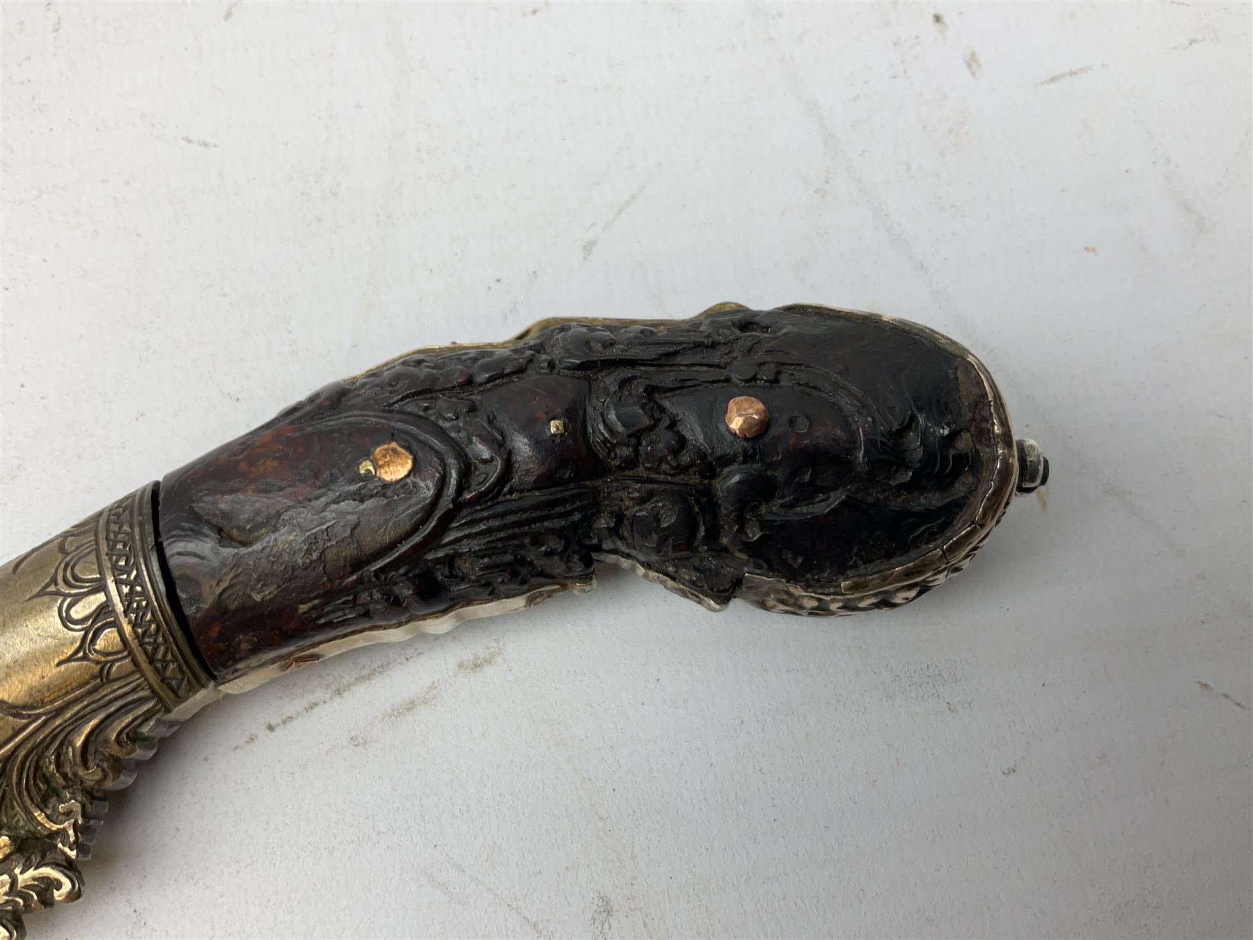 19th century Singhalese knife pia kaetta, the 20cm steel blade inset with yellow and white metal, with metal mounted carved pistol grip, in plain wooden scabbard L33cm overall