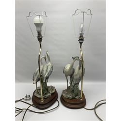 Two Florence table lamps, each lamp depicting a pair of herons upon a wooden circular base, largest H54