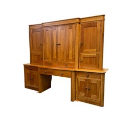Large contemporary cherry wood break-front wall unit, the banded cornice over double cupboard with bifold doors and two drawers, flanked by four single cupboards, the base fitted with four drawers over four cupboards (W263cm, H216cm, D68cm); and a cherry wood cabinet, fitted with double cupboard over two short and two long drawers, with faux drawer facias (W81cm, H138cm, D66cm)