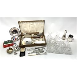 A cased silver mounted dressing table set, comprising hand held mirror, hair brush and clothes brush, with engine turned decoration and vacant plaque, hallmarked Adie Brothers Ltd, Birmingham 1954, together with a silk mounted comb, hallmarked Birmingham 1951, maker's mark worn and indistinct, a small selection of silver plate to include an Elkinton dish with squirrel modelled handle, etc., a cartwheel penny, plus a glass dressing table set. 