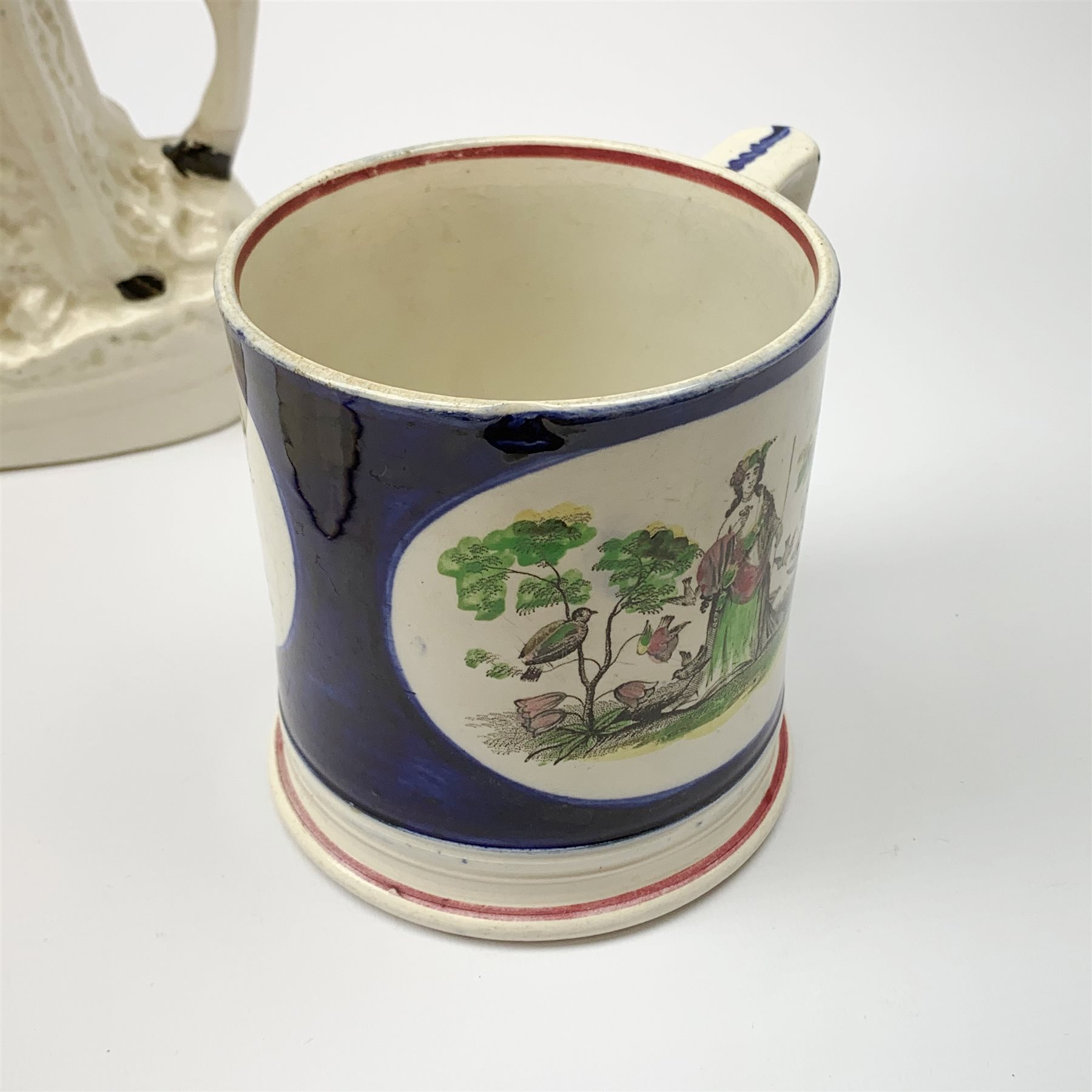 An early Victorian earthenware frog or surprise mug, decorated with printed and overpainted figural panels, H11cm, together with a 19th century child's plate detailed with a figural scene and inscribed Father Matthew administering the total abstinence pledge, 17.5cm, and a Staffordshire flat back figure seated upon a horse, H33cm. 